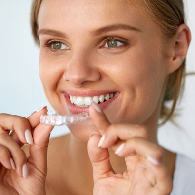 Woman holding up aligner tray
